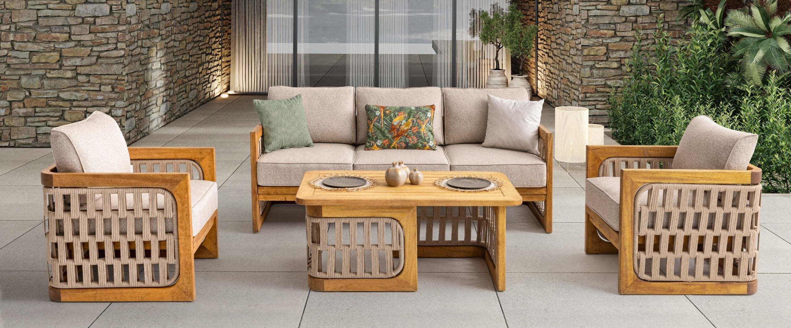 A Baxcha outdoor sofa and armchairs on a stone-walled terrace